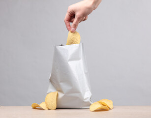 The hand takes the chips from the pack. Template for design
