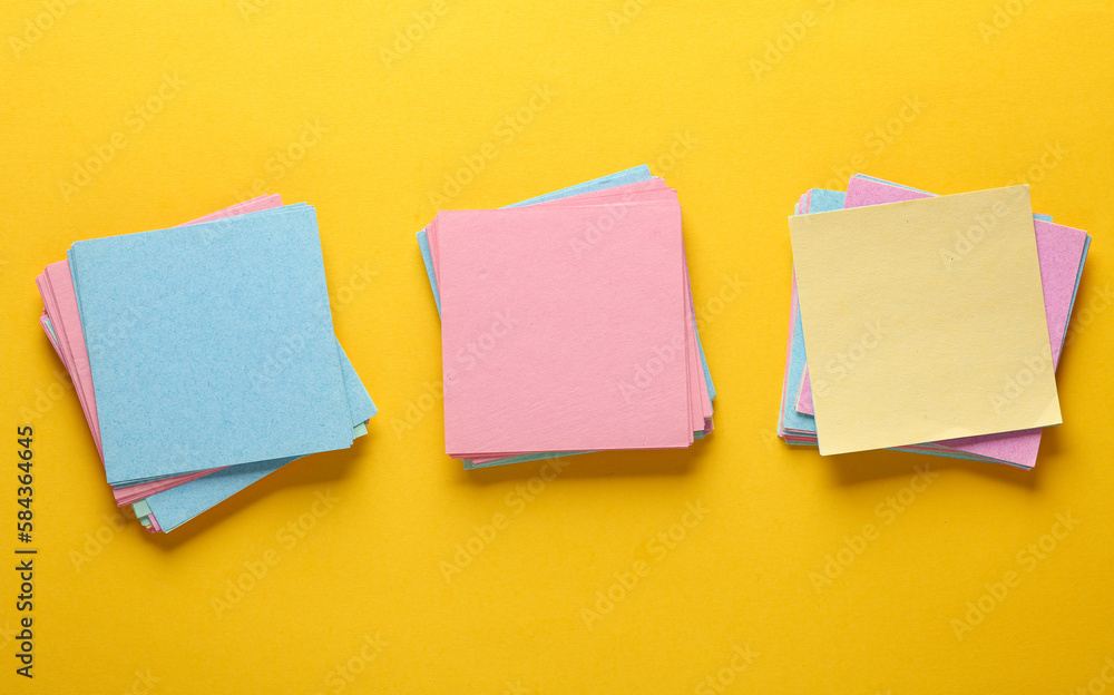 Poster colored square memo sheets of papers on yellow background. top view