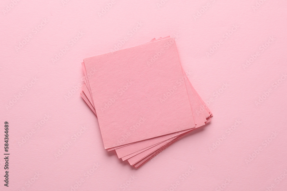 Poster stack of pink square memo sheet of papers on pink background. top view