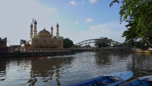 the evening atmosphere in front of the Al Misbah Mosque which is passed by the Karang Mumus River, Samarinda