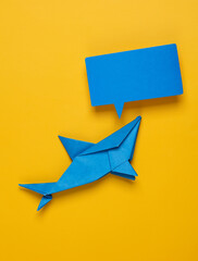 Origami shark with empty speech bubble on yellow background