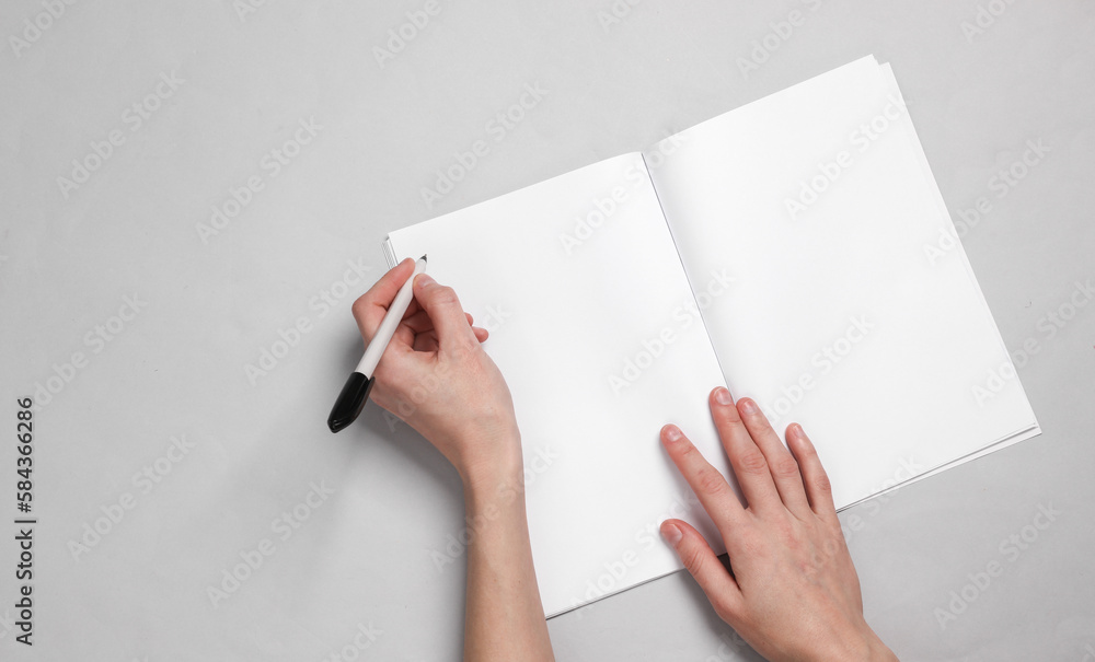 Poster women's hands write with a pen in a notebook on a gray background. white blank mockup. template for 