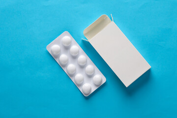 Pill blister mockup with blank cardboard box packaging on blue background. Template for design