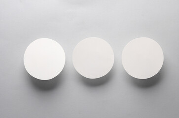 Mockup of white round coasters on a gray background. Template for design