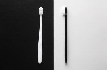 White and black toothbrushes on a white black background. Top view.