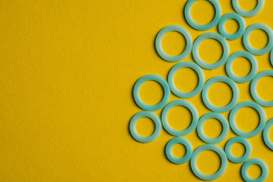 Colorful plastic rings on yellow surface
