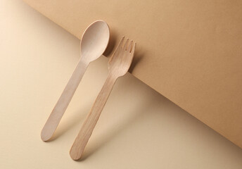 wooden fork and spoon on brown background. Creative layout. Minimalism composition. Eco concept