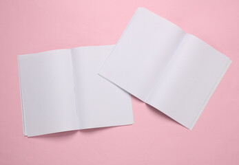 Mockup of two open magazines with white open pages on pink background. Template for design
