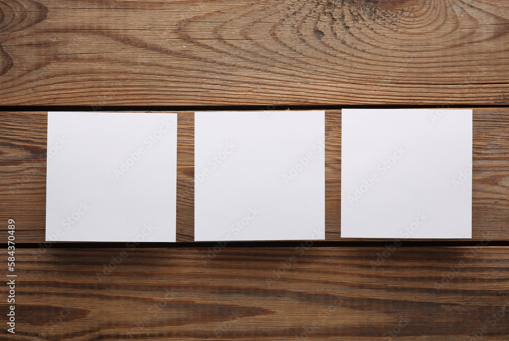 Poster white empty square memo pieces of paper on wooden table. top view