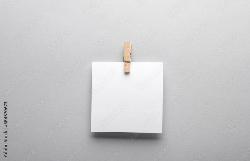 Poster white empty square memo sheet of paper with clothespin on gray background. template for design.