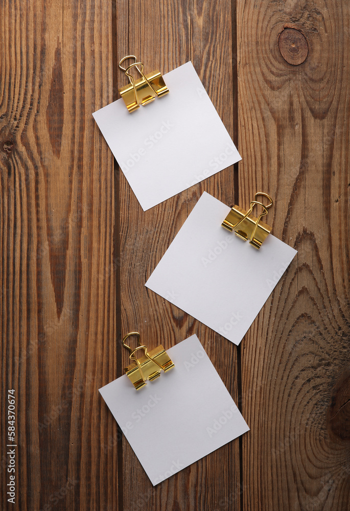 Poster white empty square memo pieces of paper with binders on wooden table. template for design.
