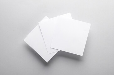 White empty square memo pieces of paper on gray background. Template for design. Top view