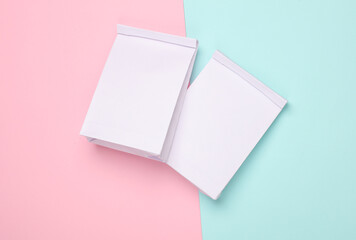 Two White paper lunch bags mockup on pink blue background. Template for design. Top view