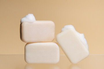Pieces of plain soap mockup with foam on a beige isolated background. Image for your design. Natural cosmetics for skin care concept.