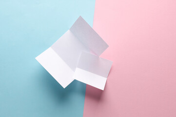 White mock up paper brochures on pink blue background. Top view