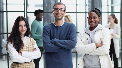 a group of three employees posing together with their arms crossed