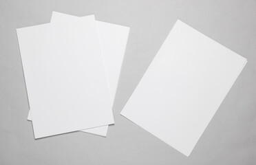 White blank sheets of a4 paper size or documents mockup on a gray background. Template for design
