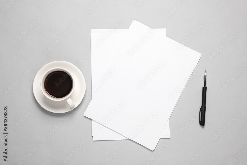 Poster white blank sheets of a4 paper size or documents mockup with pen and coffee cup on a gray background