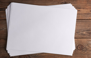 White blank sheets of a4 paper size or documents mockup on wooden table. Template for design