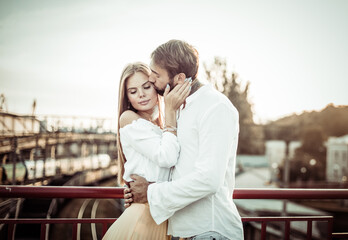 Portrait of young loving couple in urban location at sunset. Romantic concept