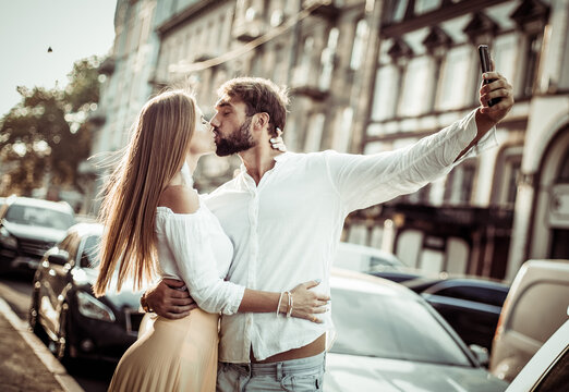 Young couple in love makes selfie on smartphone in the city. Romantic love concept