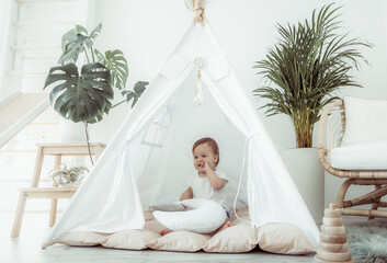 Little girl sitting in a wigwam at home © splitov27