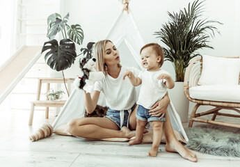 Happy woman mom and her little daughter playing in wigwam at home © splitov27