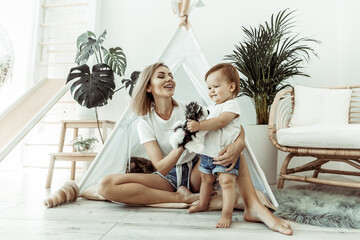 Happy woman mom and her little daughter playing in wigwam at home © splitov27
