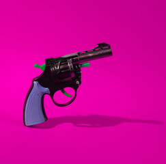 Toy gun on pink background
