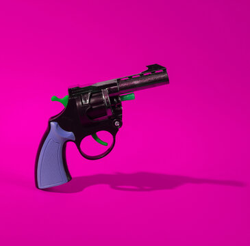 Toy gun on pink background