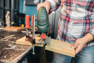 Woman using a jigsaw on a wooden, DIY Concept