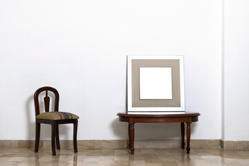 Minimalismo de cuadro en mesa de madera y silla en pared blanca