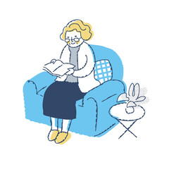 ソファーに座って本を読むシニア女性