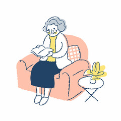 ソファーに座って本を読むシニア女性