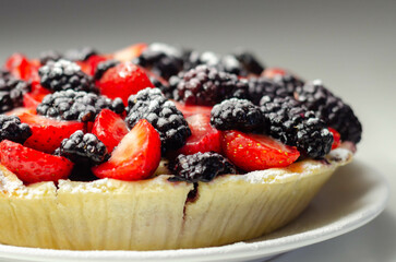 Butter enriched shortcrust pastry topped strawberries and blackberries, seasonal cake with colorful decoration