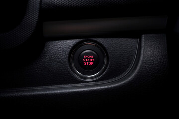 The dashboard shows details of the start button in the car. red engine start and stop button. A car engine that starts and stops with the push of a button.