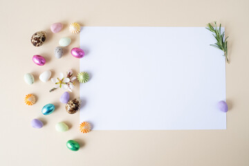 Creative Easter layout, chocolate and decoative eggs on a beige background.