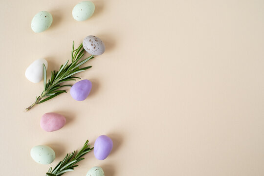 decorative eggs and rosemary on a beige background