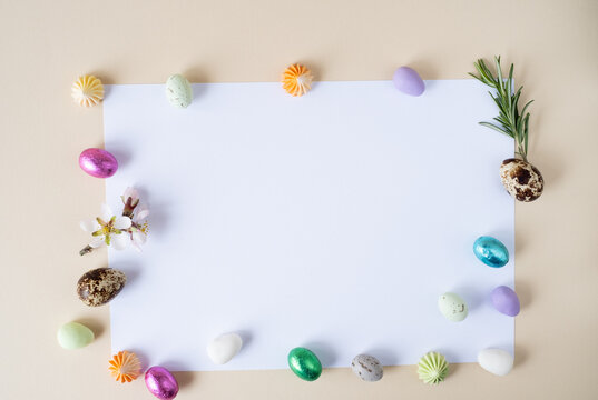 Creative Easter layout, chocolate and decoative eggs on a beige background.