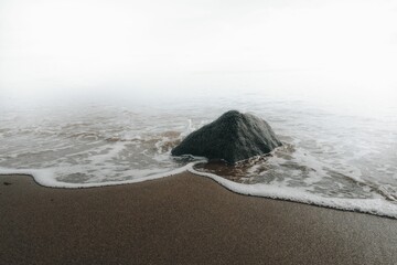 Big rock at the beach on a gloomy day