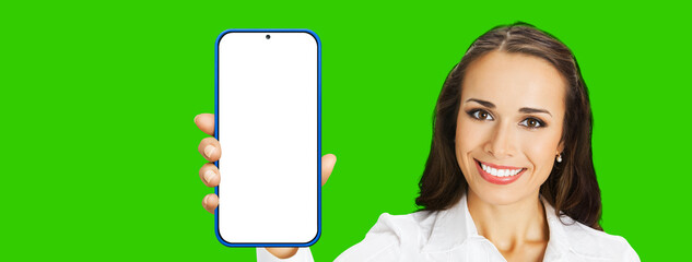 Image of excited smiling young woman in confident cloth, holding show smartphone cell phone mobile...