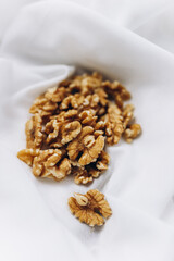 Obraz premium A pile of a walnuts on a white material 