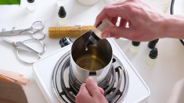 Woman making decorative aroma candle at table, closeup