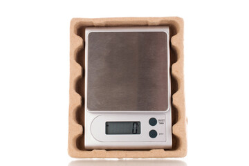 Kitchen scales in a paper box, macro, isolated on white background.
