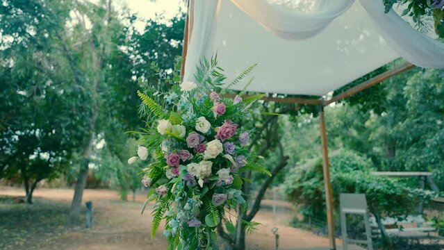 Roses and other flowers on the chuppa for a windy day wedding ceremony.