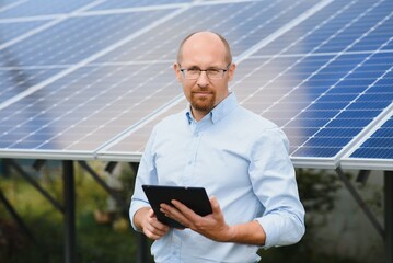 Solar energy. Young business man near the solar panels to power plants.