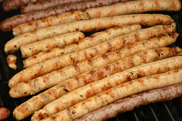 Smoking meat sausages on grill