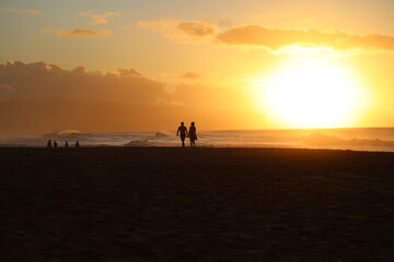 Fototapeta na wymiar silhouette of a couple walking on the beach