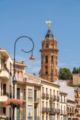 City center of beautiful Spanish city Antequera. Touristic travel destination in Andalucía. Historic and medieval city with beautiful architecture. View if buildings façade. Church tower in background