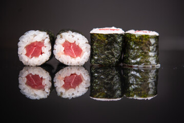 Assorted sushi rolls with salmon tuna cucumber and sesame seeds on dark background © Lemonade